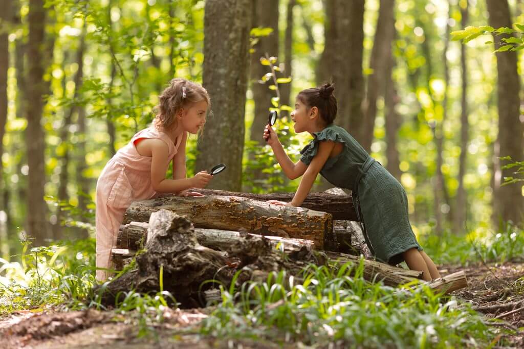 Fillettes qui jouent dans les jardins avec du bois et des loupes